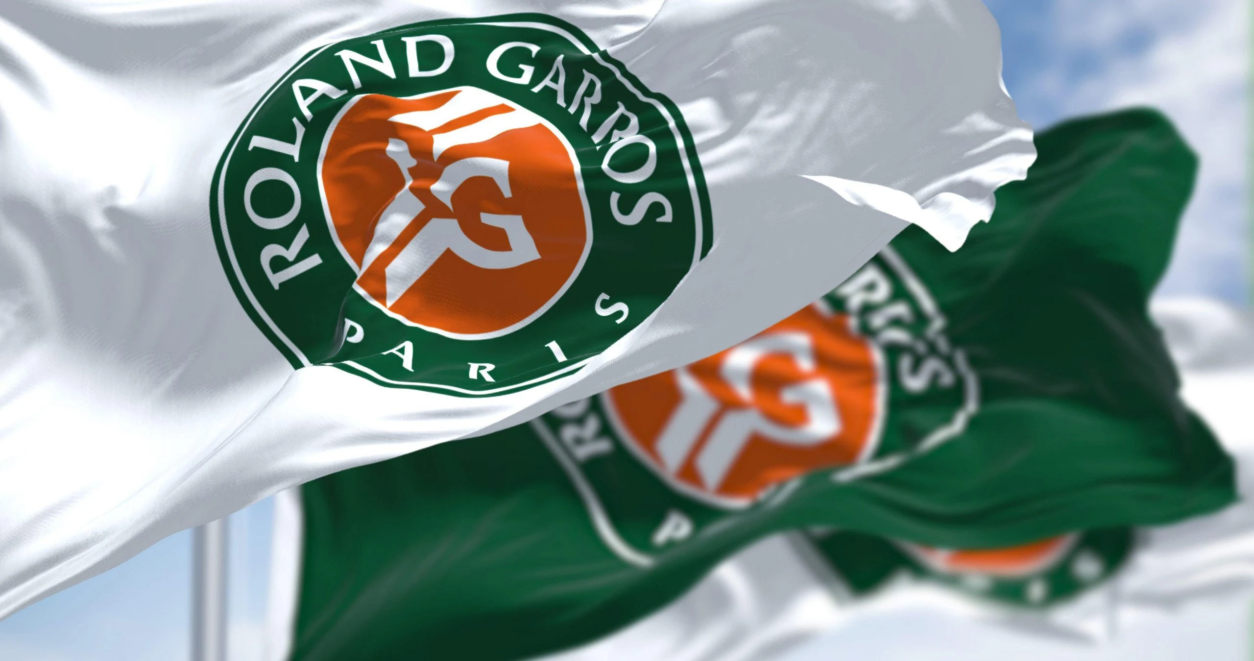 Image of three flags at the French Open tennis, bearing the legend Roland Garros